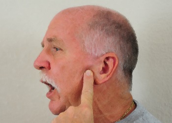 Older man pointing to his TMJ