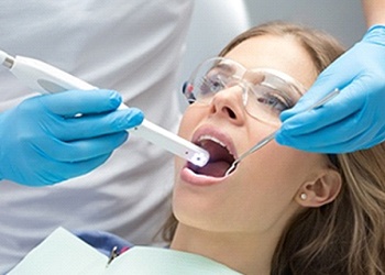 An intraoral camera being used on a female patient