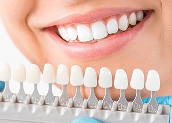 Closeup of smile compared with tooth color chart