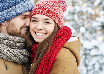 A girl smiling and a man smiling at her