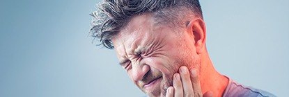 Man in pain holding cheek