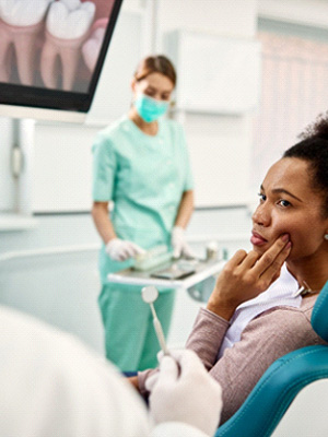 Patient with toothache looking at dentist in treatment chair