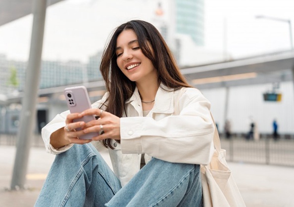 Lady smiles while reading something on phone