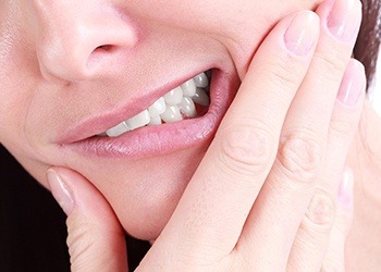 Closeup of person grimacing and holding jaw