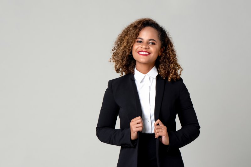 A young woman wearing a black suit and showing off her beautiful smile