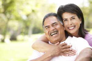 Older couple smiling and embracing.